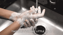 a person is washing their hands in a sink with the words twinkle twinkle little star written below them