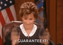 a judge is sitting in a courtroom with her hands in the air and saying `` i guarantee it '' .