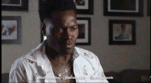 a man wearing a white shirt and a necklace with the words battlefanatic on the bottom left
