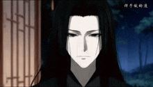 a man with long black hair is looking at the camera
