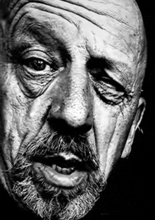 a black and white portrait of an older man with a beard .