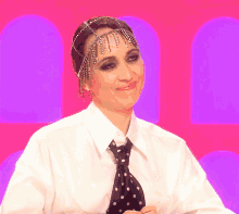 a woman wearing a polka dot tie and a headpiece