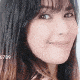 a close up of a woman 's face with a smile on her face and a blurred background .