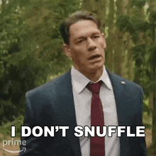 a man in a suit and tie says i don 't snuffle