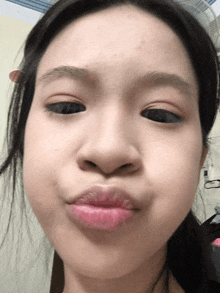 a close up of a girl 's face with a pink lip