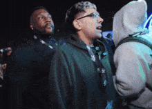 a man in a hoodie with the word icon on it stands in a crowd