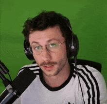 a man wearing glasses and headphones is talking into a microphone