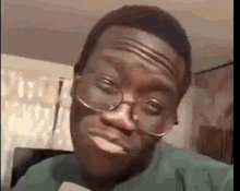 a man wearing glasses is making a funny face while looking at the camera .