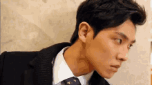 a man in a suit and tie is looking at something .