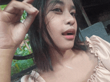 a woman in a pink top with ruffles on the sleeves