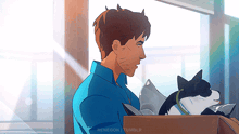 a man in a blue shirt is holding two cats in a box ..