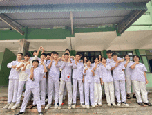 a group of young people in white shirts are posing for a photo
