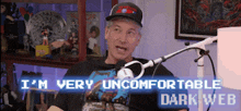 a man sitting in front of a microphone with the words i 'm very uncomfortable dark web on the bottom