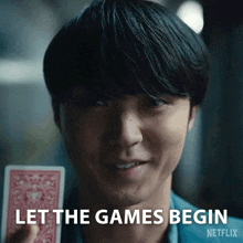 a close up of a man holding a playing card with the words let the games begin netflix written on the bottom