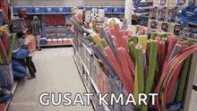 a store aisle filled with lots of water noodles and a sign that says gusat kmart .