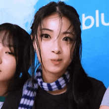 a woman with a scarf around her neck is standing next to another woman