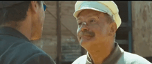 two men are talking to each other and one has a hat on