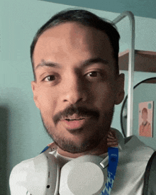 a man wearing headphones has a medal around his neck that says ' tokyo ' on it