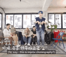 a group of young men are sitting in a living room and one of them is dancing in front of them