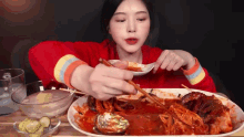 a woman is eating a large plate of food with chopsticks .