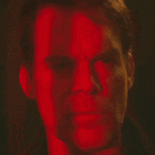 a close up of a man 's face in red light .