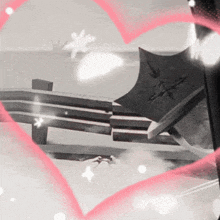 a black and white photo of a bench and umbrella with a heart in the background