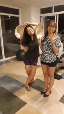 two women standing next to each other in a room