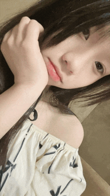 a girl with a white off the shoulder top is taking a selfie