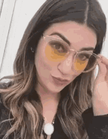 a close up of a woman wearing yellow glasses .