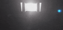a light is shining through a dark room with a blue light behind it .