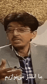 a man wearing glasses and a hat is holding a phone