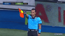 a referee holds up an orange flag during a soccer game sponsored by fox deportes