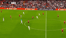 a soccer game is being played on a field with just eat advertisements