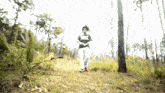 a person wearing a shirt that says ' supreme ' on it is walking through the woods
