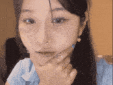 a woman with a ring on her finger looks at the camera