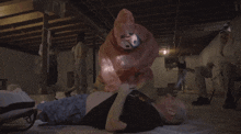 a man is laying on the floor with a pig costume on his chest
