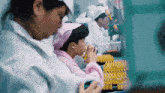 a woman wearing a pink head scarf is working in a lab
