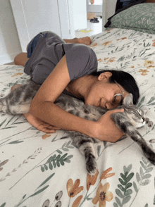 a woman laying on a bed holding a cat
