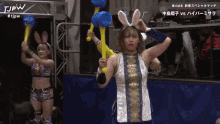 a woman in a bunny costume is holding a pair of blue balloons