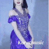 a woman in a purple dress with the word koratmusic on the bottom
