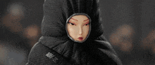 a model walks down a runway at a fashion show wearing a black sleeping bag