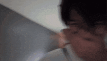 a blurry picture of a person 's face with a gray wall in the background