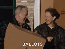 a man and a woman holding a cardboard box with the word ballots written on it