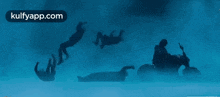 a silhouette of a man riding a motorcycle is falling into the water .