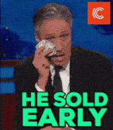 a man in a suit and tie wipes a tear from his eye with the words he sold early behind him