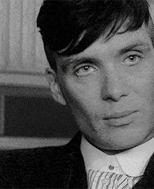 a man in a suit and tie looks at the camera