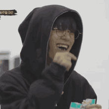 a man wearing glasses and a black hoodie with a yellow sticker that says ' korean ' on it