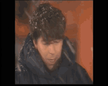 a close up of a man 's face with snow on his head