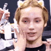 a close up of a person 's face with a brush in the background