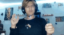 a man wearing headphones and a microphone is making a face .